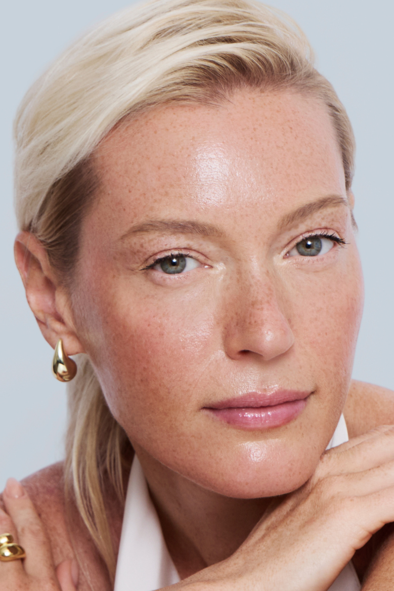 Woman with a jar of cream on a light gray background