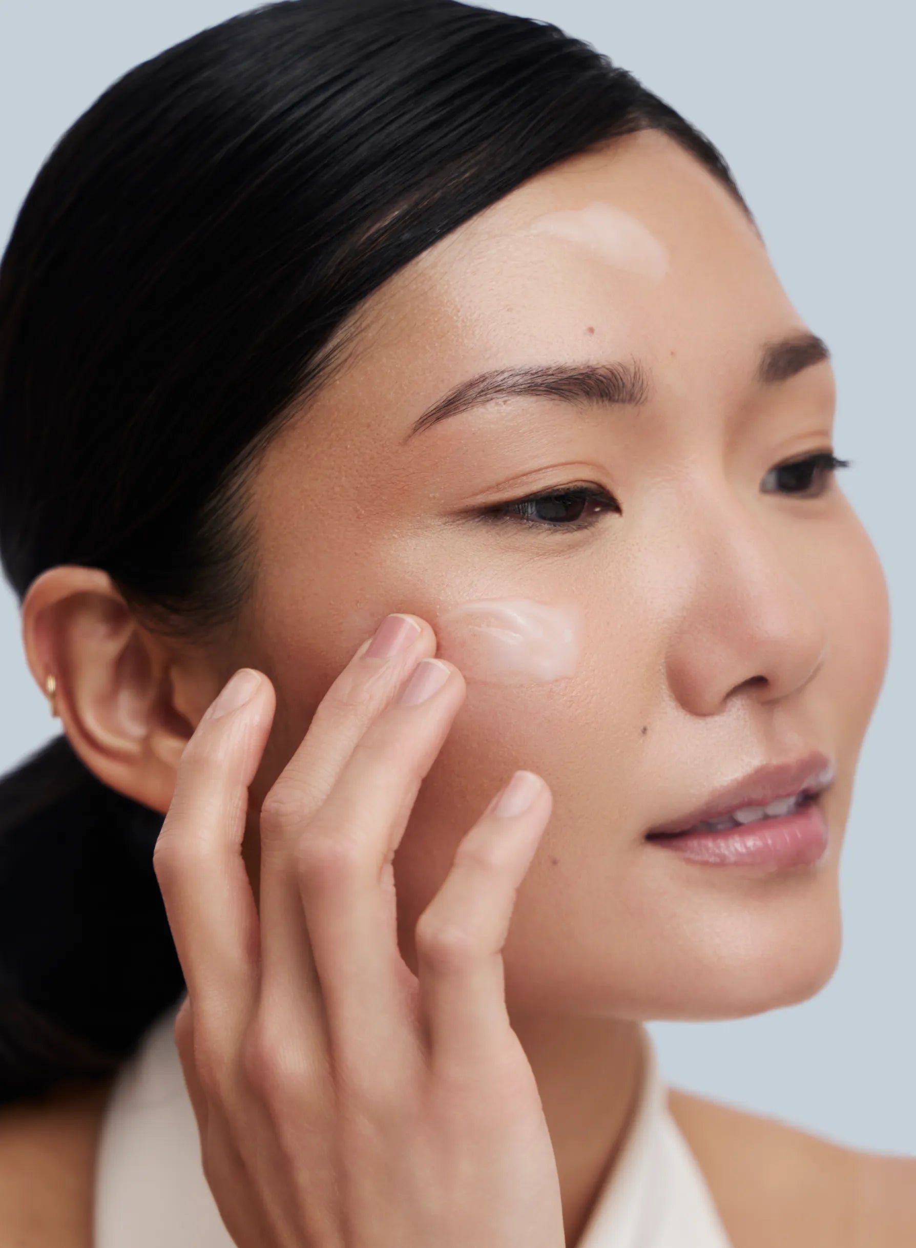 Asian Model applying zBigatti Skin Treatment on her face