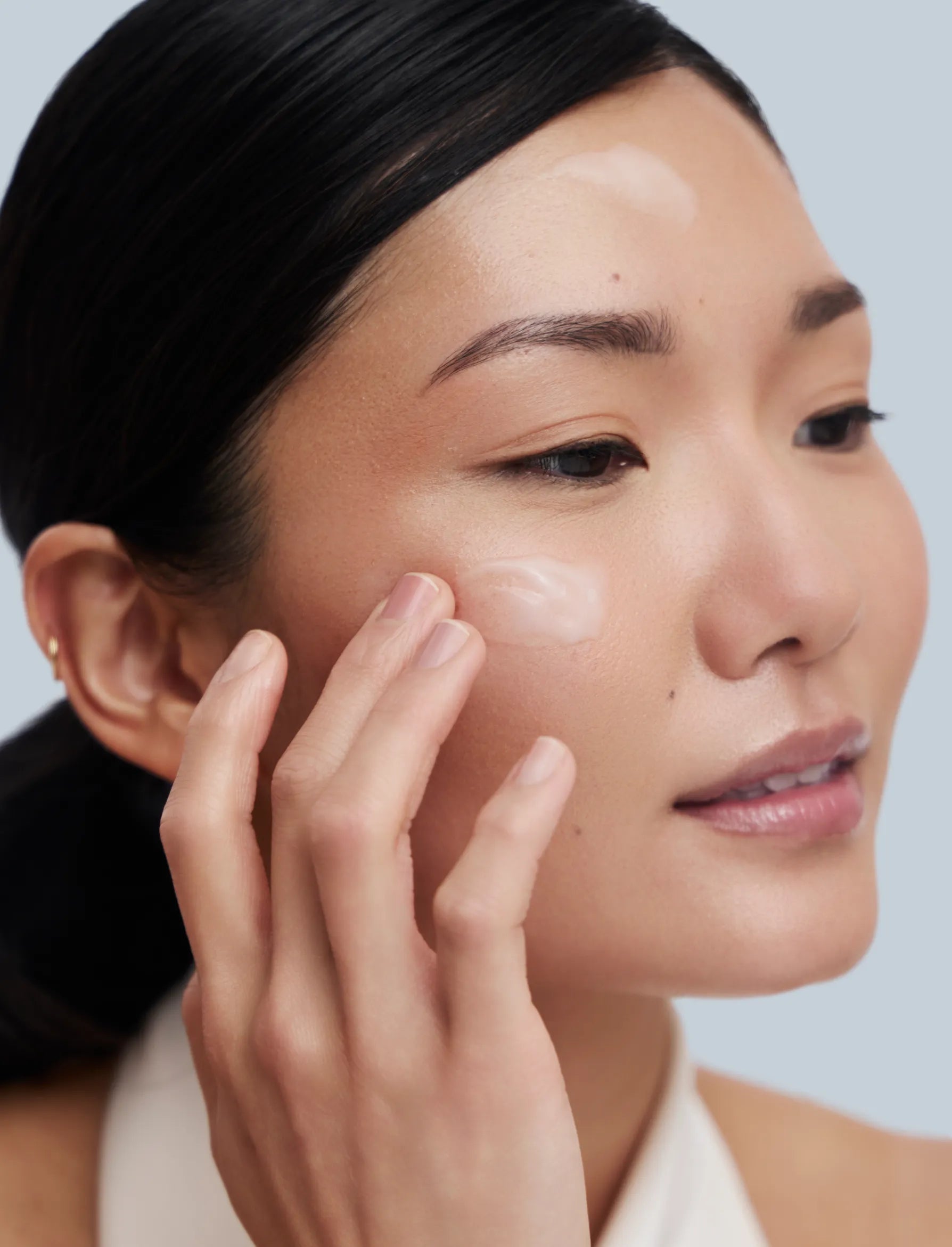 Asian woman Applying zBigatti Re-Storation Skin Treatment