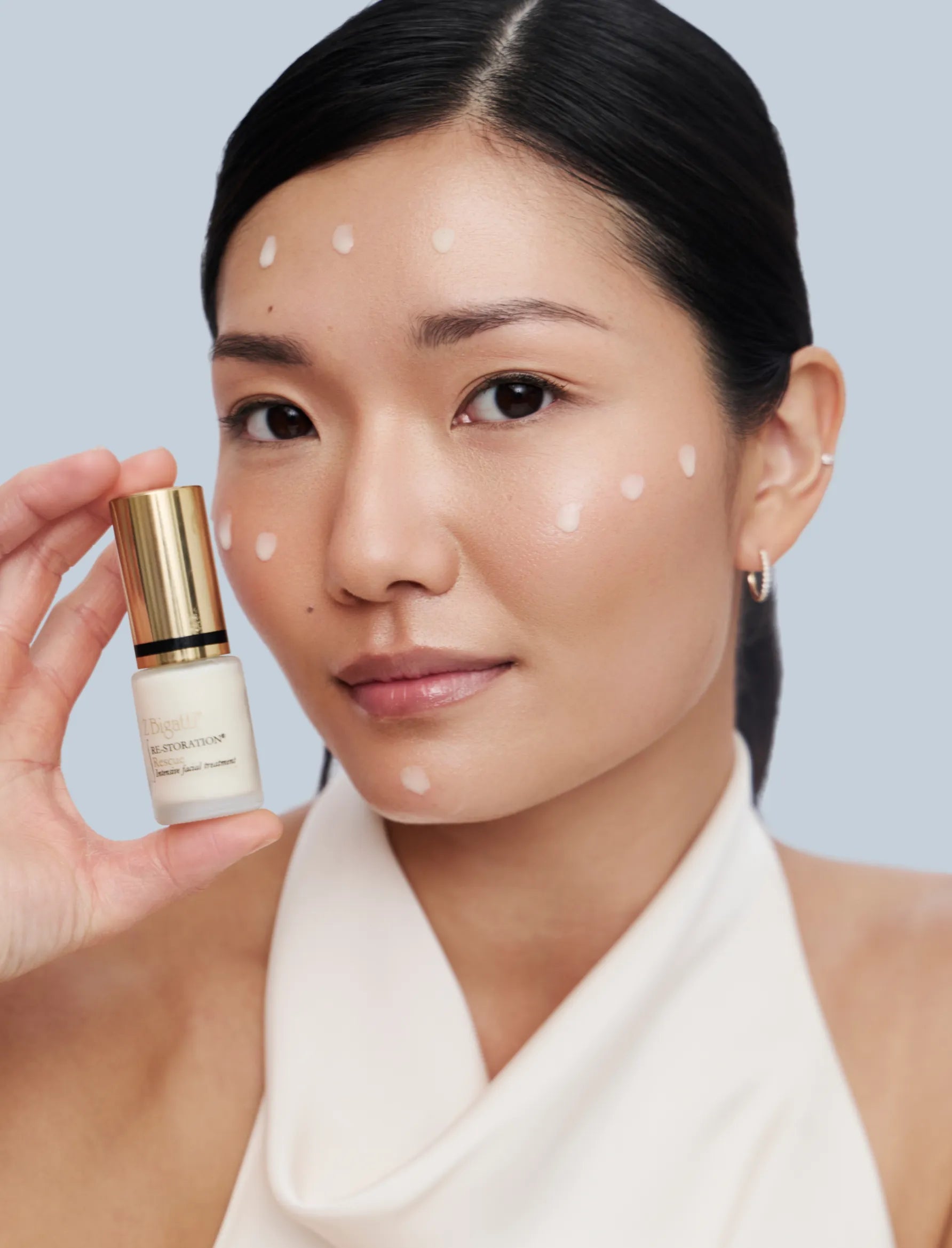 Studio Portrait of Asian woman holding Rescue serum