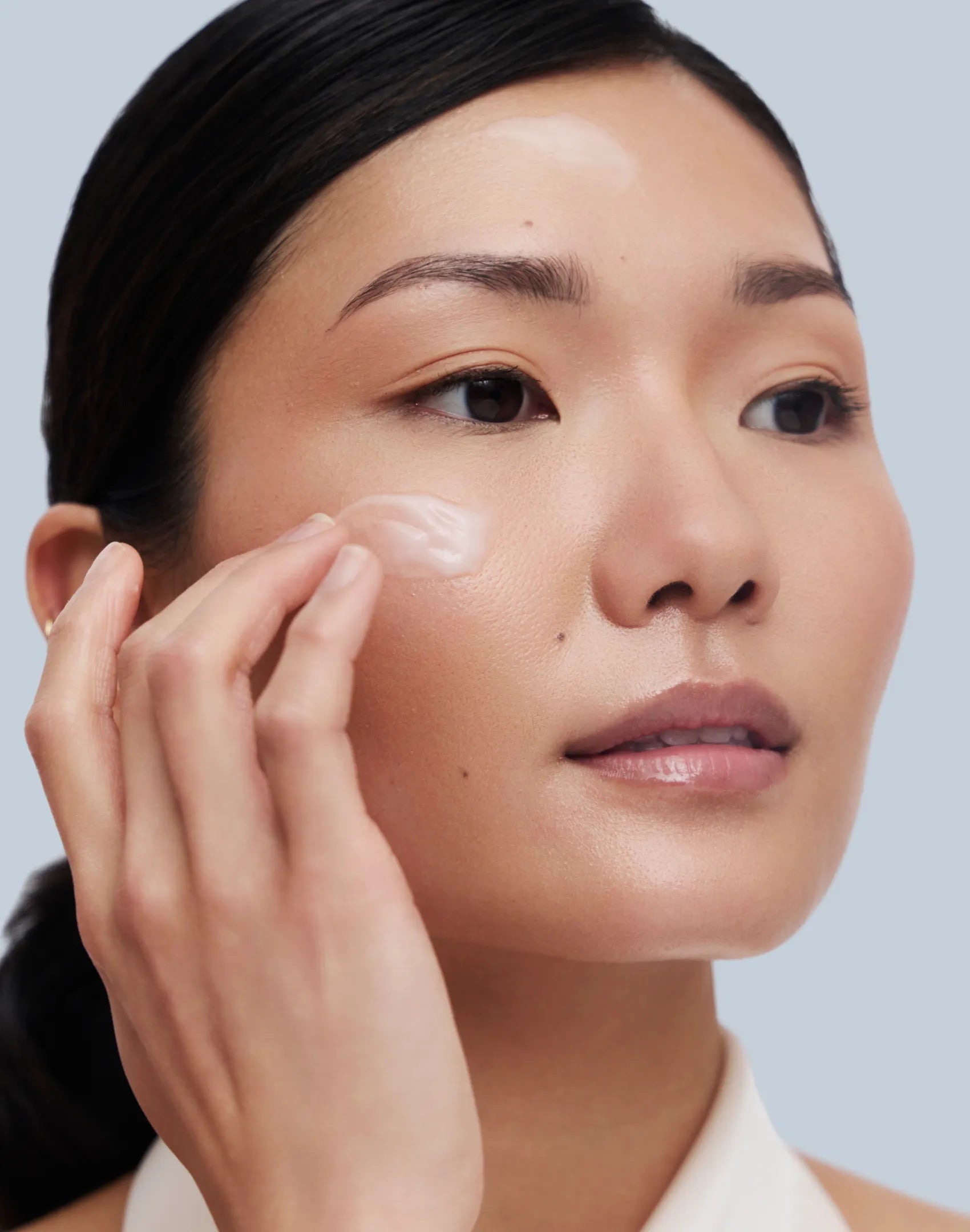 Asian Model applying Rescue serum on her face